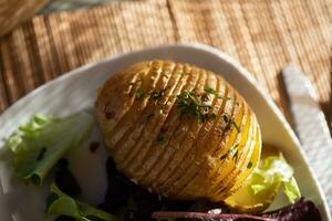 Baked jacket potatoes with dip, mixed green salad leaves and hemp oil photo