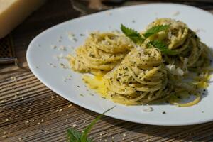 un plato de pasta con un verde hoja en parte superior foto