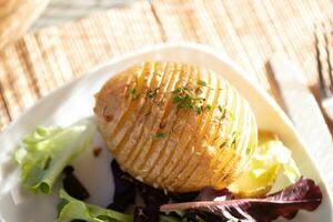 Baked jacket potatoes with dip, mixed green salad leaves and hemp oil photo