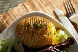 Baked jacket potatoes with dip, mixed green salad leaves and hemp oil photo