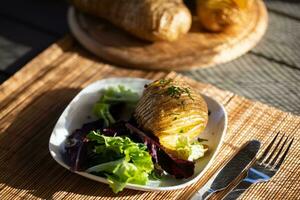 Baked jacket potatoes with dip, mixed green salad leaves and hemp oil photo