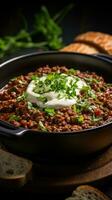 Spicy chili con carne topped with sour cream and chives photo