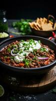 Spicy chili con carne topped with sour cream and chives photo