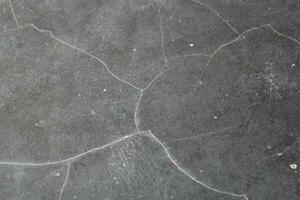 Dark cracked floor surface, shiny deep dark background, grungy floor background photo