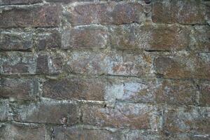 Weathered brick layer wall background, grungy brick texture surface, aged wall texture photo