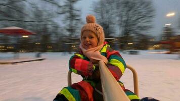 Little child having exciting ride on playground spinner, winter view video