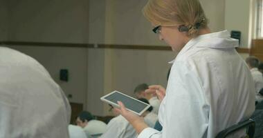 médico estudiante tomando notas en almohadilla durante conferencia video