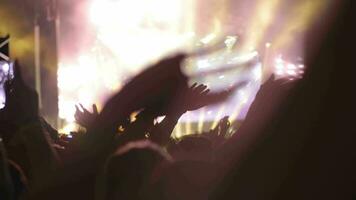 A crowd of music fans waving hands on an open air concert video