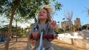 alegre criança em a gangorra em Parque infantil video