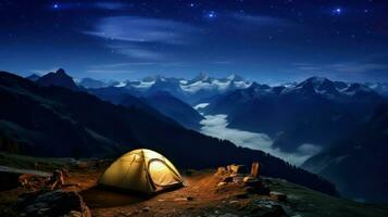 Camping in the mountains at night. The tent is on the top of the mountain. photo