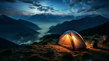 Camping in the mountains at night. The tent is on the top of the mountain. photo