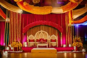 an indian wedding stage decorated with red and yellow flowers. AI-Generated photo