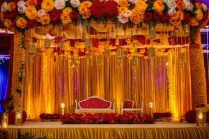 a wedding stage decorated with red and yellow flowers. AI-Generated photo