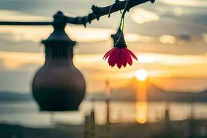 a flower hanging from a wire with the sun setting behind it. AI-Generated photo