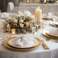 Elegant gold and white table setting with wreath and candles photo