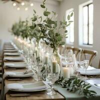 Minimalist white and green tablescape with eucalyptus and candles photo