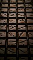 Artful chocolate tiling, Close-up view of carefully crafted dark chocolate squares Vertical Mobile Wallpaper AI Generated photo