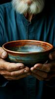 Empty bowl held by elderly hands, symbolizing the stark reality of hunger Vertical Mobile Wallpaper AI Generated photo