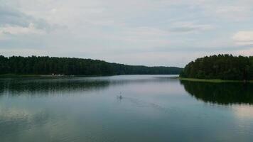 A man on a SUP floats on the surface of Asveja the longest lake in Lithuania video