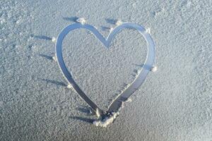 heart drawn in the frost on the hood of the car photo