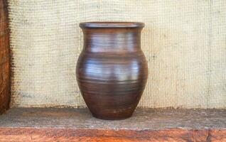 Clay pot on a shelf. Shelves with standing on their utensils of porcelain and earthenware. Vintage kitchen utensils photo