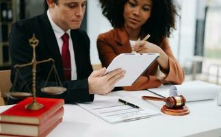 Business and lawyers discussing contract papers with brass scale on desk in office. Law, legal services, advice,  justice and law concept . photo