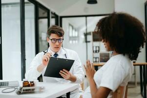Doctor and patient discussing something while sitting at the table . Medicine and health care concept. photo