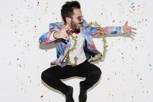 Stylish man wearing a colorful suit and sunglasses celebrating a party and jumping photo