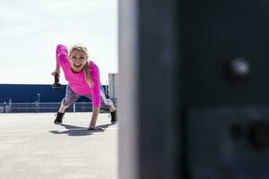 Woman training with dumbells, doing one-armed plank photo