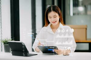 Asian Businesswoman hand Project manager working and update tasks and Gantt chart scheduling virtual diagram.with smart phone, tablet and laptop in office. photo