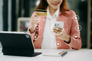 Woman using smart phone for mobile payments online shopping, omni channel, sitting on table, virtual icons graphics interface screen photo