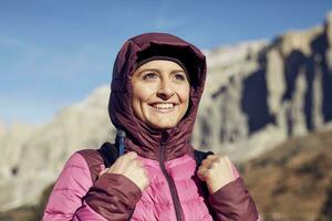 Portrait of confident young woman hiking in the mountains photo