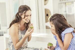 contento madre y hija comiendo aguacate un pan a hogar foto