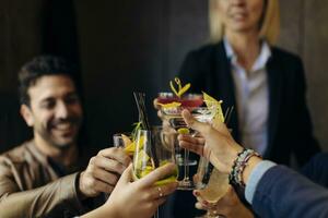 colegas tostado con cócteles en un bar foto