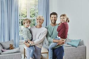 retrato de contento familia con dos niños a hogar foto