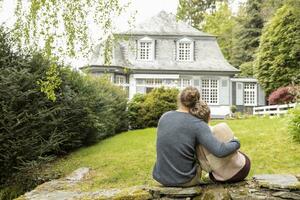 Rear view of couple sitting on a wall in garden photo