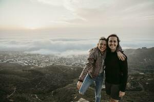 South Africa, Cape Town, Kloof Nek, portrait of two happy women embracing at sunset photo