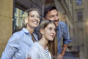 Portrait of happy family behind windowpane photo