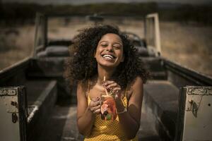 Portrait of laughing woman drinking fresh ice tea drink at safari bus photo