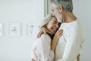 Affectionate mature couple hugging at home photo