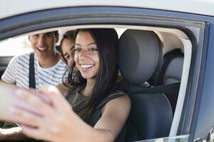 amigos teniendo divertido en un la carretera viaje, tomando teléfono inteligente selfies foto