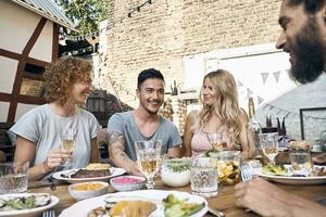 Friends having fun at a barbecue party, eating together photo