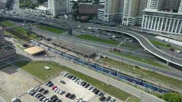 ett antenn se av en upptagen motorväg Nästa till de järnväg station och urban byggnader video