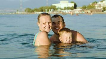 Happy parents and son bathing in sea on resort video