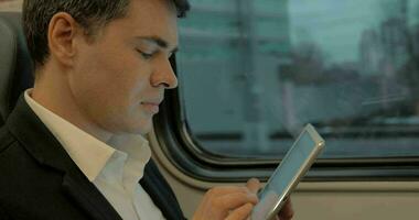 joven empresario chateando en almohadilla en el tren video
