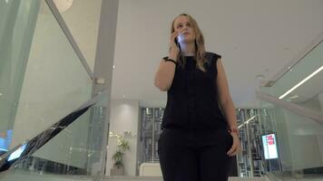 A young woman talking to a smartphone while going downstairs video