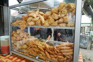 various types of snacks that are fried and sold on glass display case photo