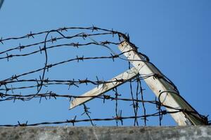 barbed wire on top of the wall fence. concept photo illustration of criminals escaping from prison