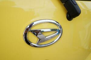 The Daihatsu logo on the car body is yellow. Bontang, East Kalimantan, Indonesia. September 21 2023 photo