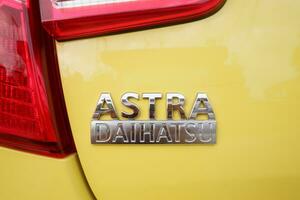 The Daihatsu Astra emblem on the car body is yellow. Bontang, East Kalimantan, Indonesia. September 21 2023 photo